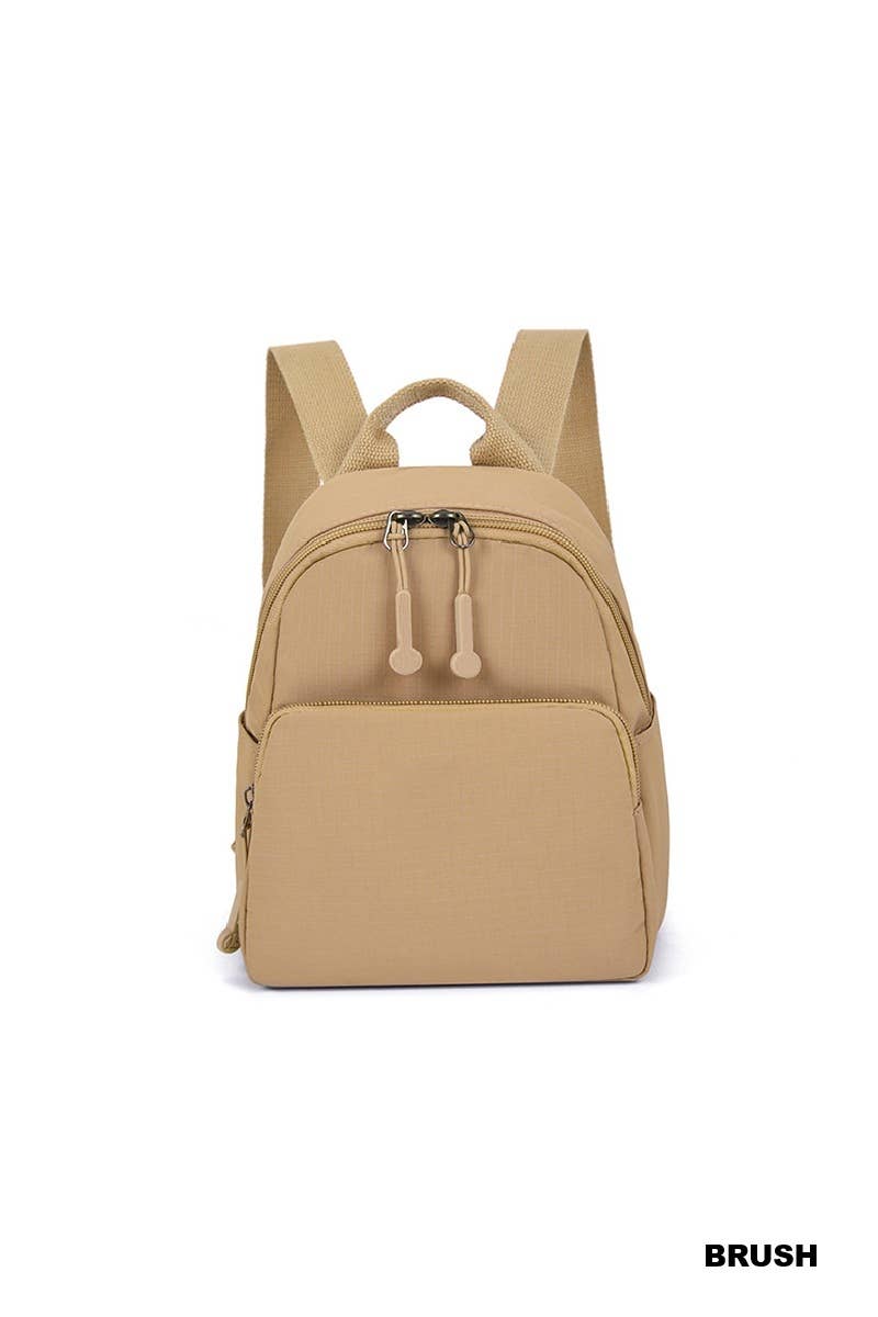 A beige canvas backpack with dual top handles, a top zippered compartment, and a front zippered pocket, shown against a plain white background.